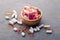 Assortment scattered pharmaceutical medicine vitamins, pills, drugs in wooden bowl on gray background. White food dietary