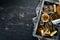 Assortment of sprats and snacks. In a wooden box. On a black background. top view.