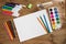 Assortment of stationery for drawing on wood background. Colored pencils, paints, felt tips, brushes for children`s creativity.