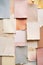 Assortment of textured papers in pastel hues arranged in layered collage. Chaotic paper cards background