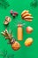 Assortment of tropical fruits and orange smoothie bottle on vibrant bold green background. Pineapple, kiwano, kiwi , lichee and
