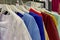 Assortment of variety of casual clothes hanging on rack at shop boutique for sale. Close-up