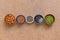 Assortment of various seeds in a bowl arranged in a line on a stone background. Sesame, flax, chia, pumpkin, almonds. Top view,