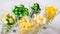 Assortment of yellow and green cut vegetables in shot glass on white background.