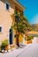 Assos village. Traditional yellow colored greek house with bright blue door and windows. Fucsia plant flowers around