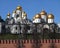 Assumption Cathedral, Annunciation Cathedral with golden cupolas behind the Kremlin wall view from embankment of the Moscow river