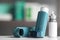 Asthma inhalers on table against blurred background