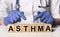 Asthma word, inscription on cubes in doctor hands