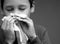 asthmatic breathing problems catching the flu child blowing nose after having a cold on grey background with people stock photo