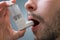 Asthmatic man suffers from asthma and is using inhaler