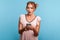 Astonished beautiful young adult woman in summer dress, using smartphone and watching shocking video, reading message with amazed