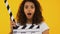 Astonished girl using clapper board, shocking content, highest-rated movie