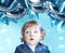 Astonished little boy looking at blue balloons