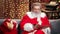 Astonished male in Santa Claus costume reading wish list Christmas gifts. Medium shot on RED camera