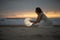 Astrology. Secret and riddle. Beautiful attractive girl on a night beach with sand hugs the moon, art photo