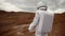 Astronaut explores an unknown red planet. Cloudy sky and mountains in the background