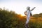 Astronaut futuristic kid girl with white full length uniform and helmet wearing silver shoes outdoors