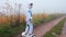 The astronaut on a gyroscooter rides along the road in the fog.