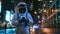Astronaut in Space Suit Using Smartphone in Urban Night Setting