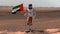 Astronaut walking on Mars with UAE flag. Exploring Mission To Mars Red Planet. Futuristic Colonization Space Exploration Concept.
