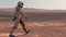 Astronaut wearing space suit walking on the surface of Mars. Exploring mission to mars. Futuristic colonization and