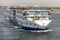 Aswan, Egypt - September 16, 2018: Floating hotels tourist boats motor down the River Nile towards Aswan in central Egypt. The