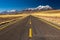 Atacama straight road and snow covered volcanoes