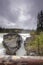 Athabasca Falls in the Rocky Mountains of Canada. Between the cliffs above the water stuck logs. Cloudy day in Jasper