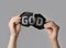 Atheism as religious position. Woman ripping black paper with word God on light grey background, closeup