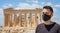 Athens Acropolis, Greece coronavirus days. Young man wearing protective face mask on Parthenon temple and blue sky background