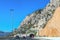 Athens to Corinth Highway Greece Mountainside Tunnels with traffic and retaining fences on side of mountain under clear blue sky