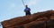 Athlete adjusting his rope on waist while standing on cliff 4k