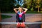 Athlete blonde with hands behind head practicing on wooden bench in park on summer.