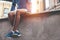 Athlete in blue running shoes sitting and resting after street workout session at sunset