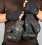 athlete in brown clothes holds very old vintage leather boxing gloves