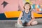 Athlete Caucasian boy sitting on trampoline after training. child is engaged in trampolining on professional trampoline outside.