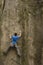 Athlete climbs on rock with rope.