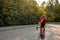 athlete cyclist in black helmet and active wear dynamically riding bicycle drinking water