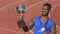Athlete holding cup in hands, celebrating victory in sports competition, triumph