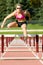 Athlete Jumping Over Hurdles on a Track