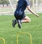 Athlete jumping over two foot high yellow hurdle