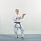 Athlete in karategi trains formal exercises on gray cover