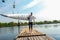 Athlete with kayak on her shoulder going on wooden dock