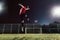 Athlete kicking soccer ball towards goal