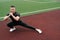 The athlete makes lunges, exercise to warm up before training. Male bodybuilder trains on sports ground