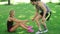Athlete man help young woman stand up from green lawn. Sport people teamwork