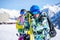 Athlete man and woman snowboarders standing on snow resort against backdrop of mountain.