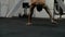 Athlete with naked torso doing walk on his hands while standing upside down.