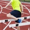 Athlete performing hurdle walk over drills on a track