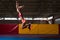 Athlete Performing a Long Jump In Gym